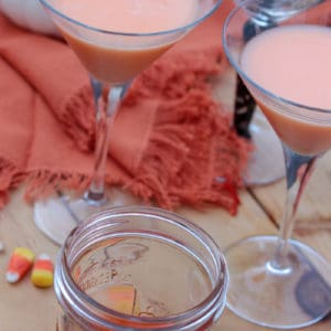 Candy Corn Martinis with candy corn vodka and candy corn in the background