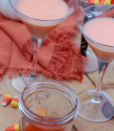 Candy Corn Martinis with candy corn vodka and candy corn in the background