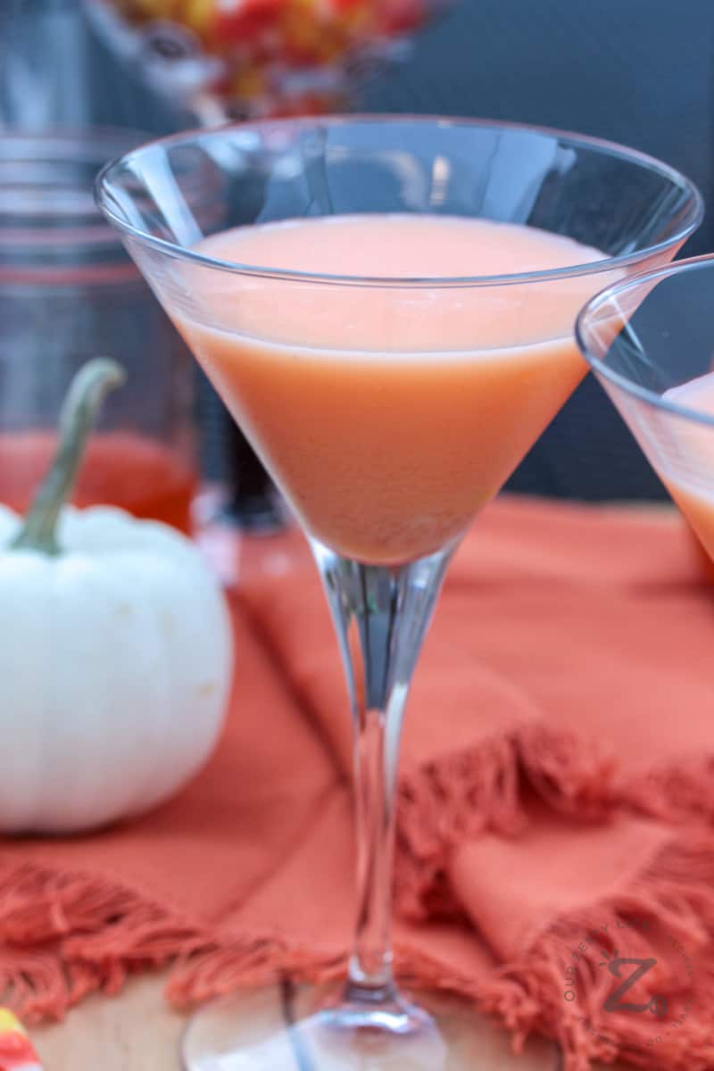 a Candy Corn Martini with a pumpkin and a jar of Candy Corn Vodka in the background