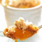 Easy Peach Crisp Recipe with peach crisp and ice cream on a spoon with an individual easy peach crisp in the background