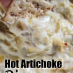taking Artichoke Dip on a cracker from the serving dish