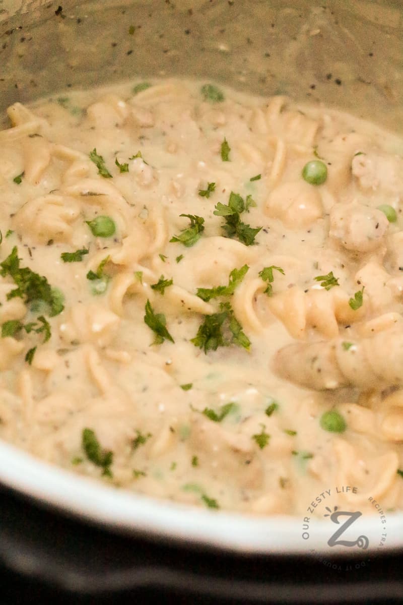 Instant Pot Italian Chicken and Noodles and peas in the Instant Pot bowl garnished with parsley