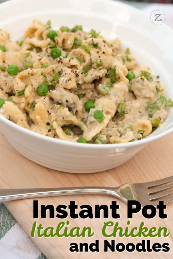 Instant Pot Creamy Chicken and Noodles and peas in a white bowl garnished with parsley and a fork on the side