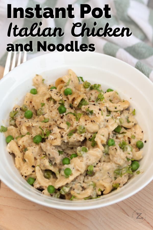 Instant Pot Chicken and Noodles and peas in a white bowl garnished with parsley with a fork and towel on the side