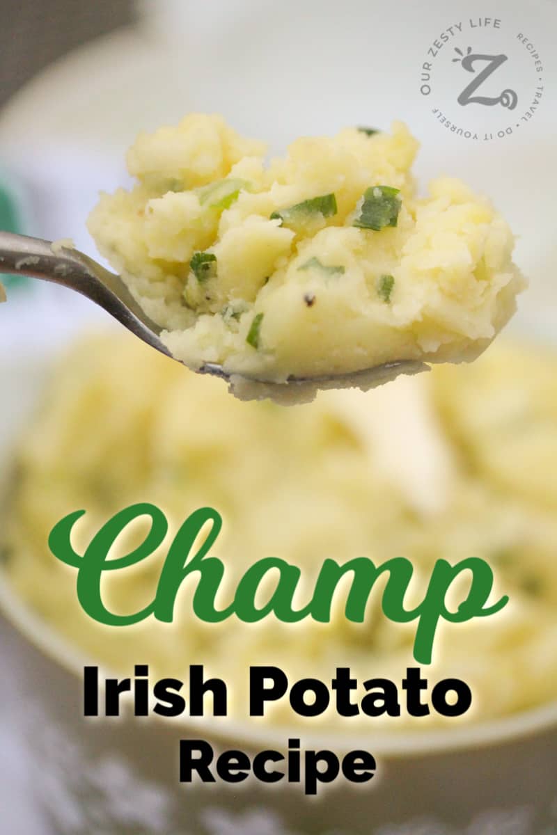 closeup of a bite of Irish Champ on a spoon with a serving dish of Irish mashed potatoes in the background