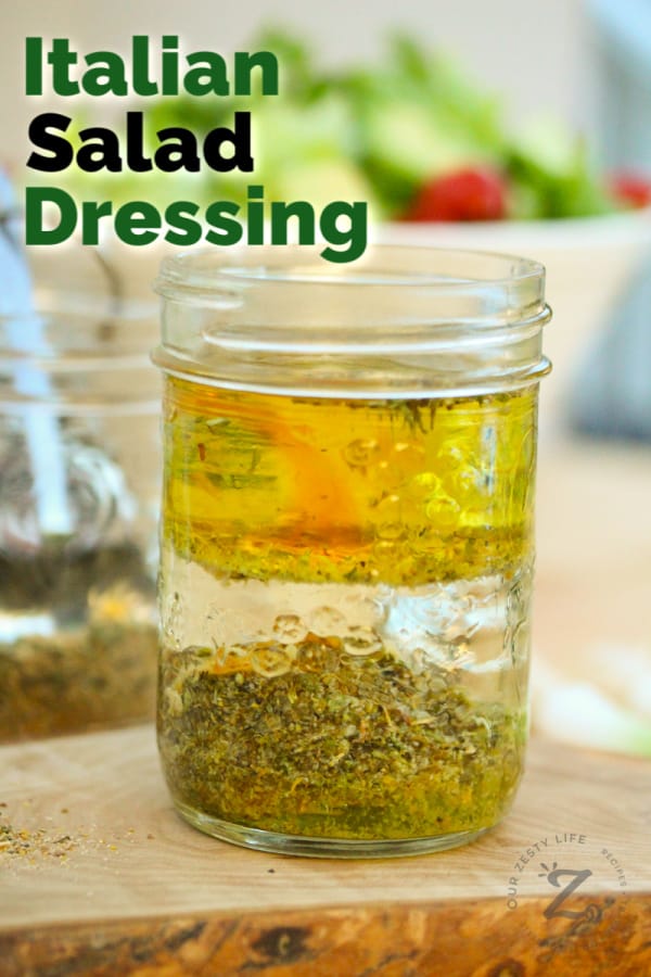 homemade Italian dressing layered in a mason jar not mixed with a salad in the background