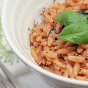 close up of Parmesan Orzo with basil in a white bowl