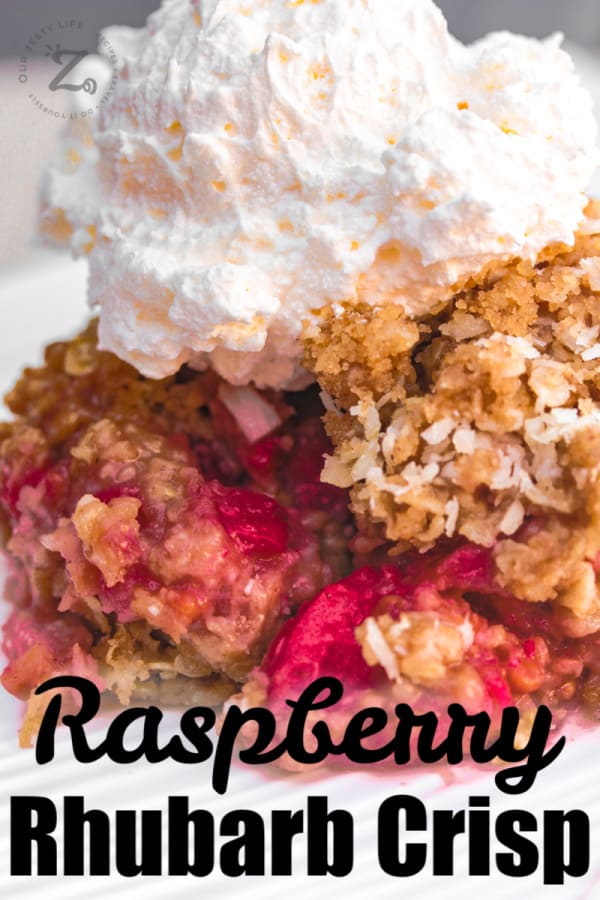 a serving of raspberry rhubarb crisp on a white plate with a scoop of vanilla ice cream on top