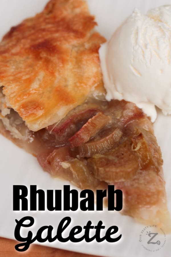 close of up of a slice of baked rhubarb galette (easy rhubarb pie on puff pastry) with a scoop of vanilla ice cream on a white plate