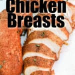 sliced smoked chicken breast with whole chicken breast on a white cutting board