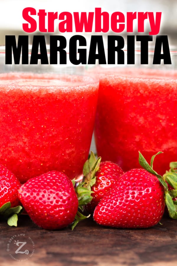 close up of two glasses of fresh strawberry margarita with fresh strawberries in front