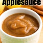 Instant Pot applesauce in a small white bowl with apples in the background