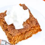 a piece of Pumpkin Pie Crunch with whipping cream and a fork on the side