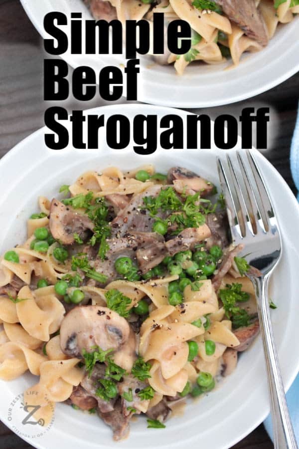 Beef stroganoff with mushrooms and peas on a white plate with a fork