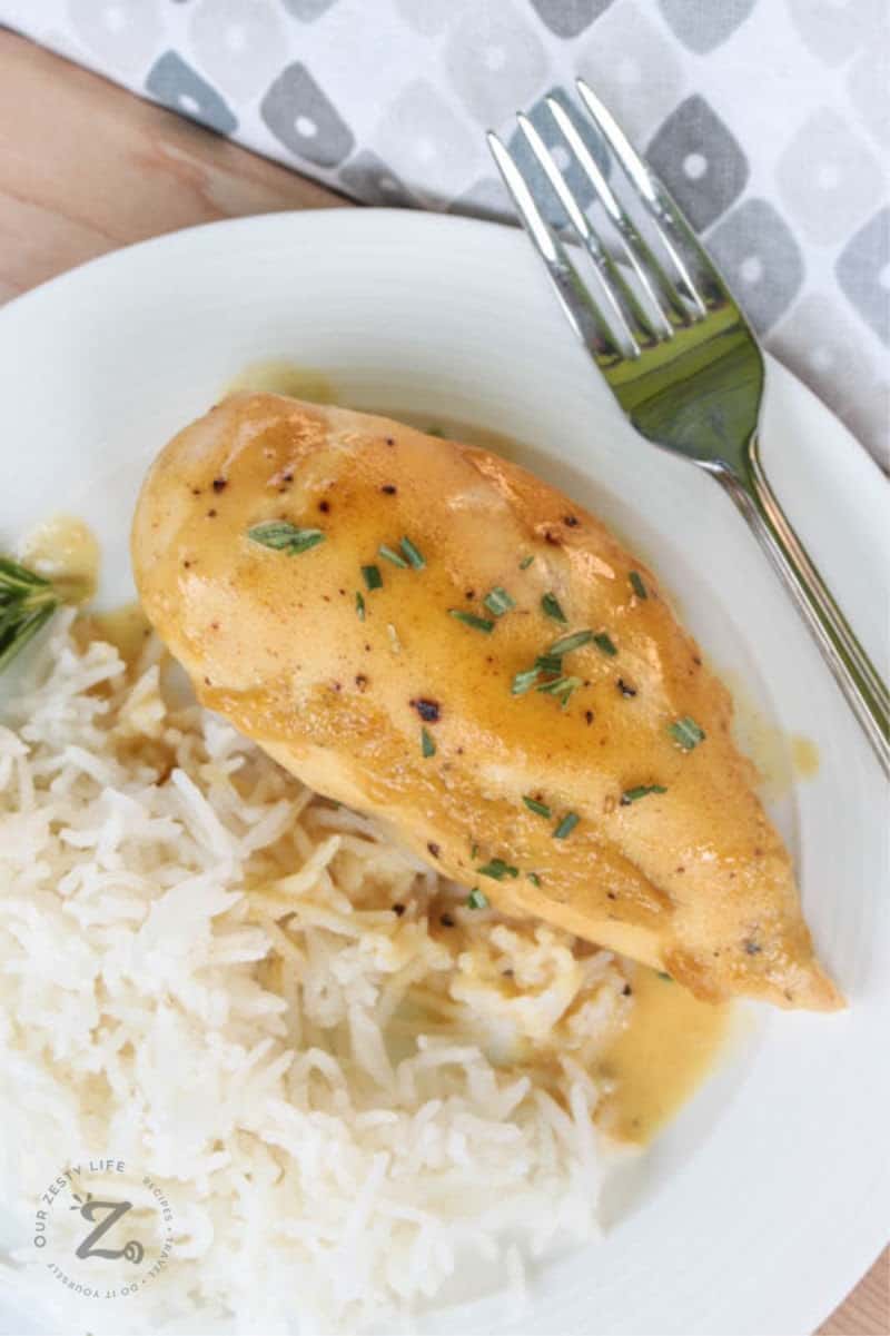 Dijon chicken on a plate with white rice and a fork