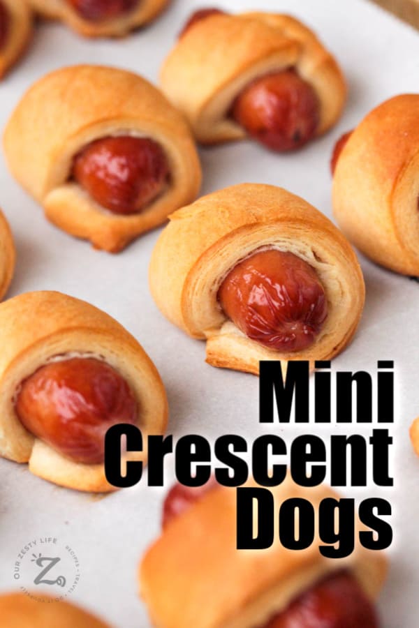 picture close up of 6 baked mini pigs in a blanket on a cooking sheet