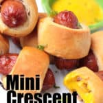 Close up of 5 mini pigs in a blanket beside some mustard dipping sauce