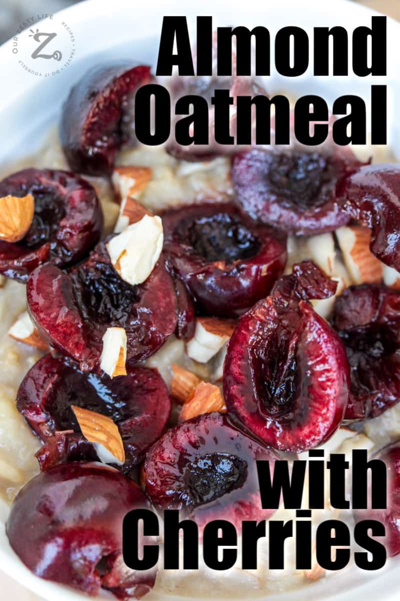 overhead view of 10-12 pitted cherries sliced in half on top of oatmeal and almond milk in a bowl