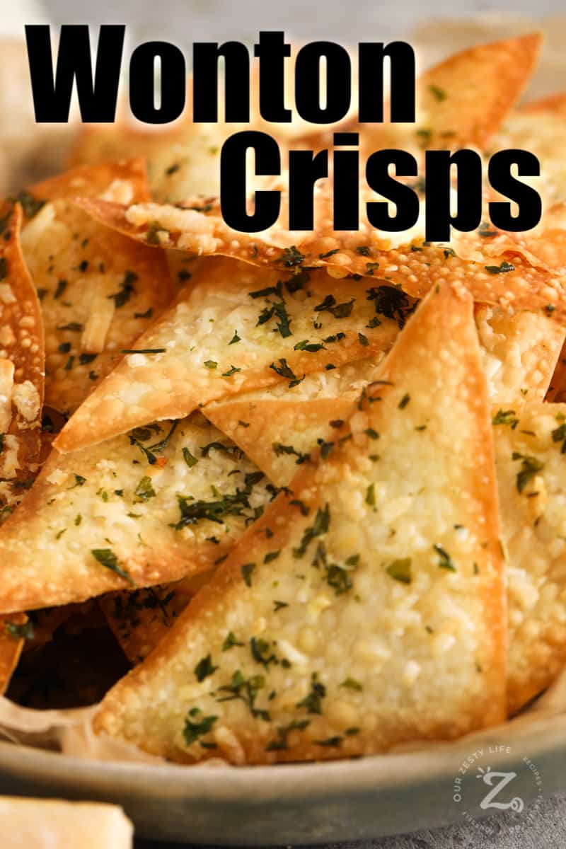 A close up of baked parmesan and parsley wonton crackers in a bowl