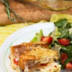 Breakfast strata sliced in squares and on a plate with salad.