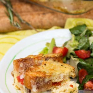 Breakfast strata sliced in squares and on a plate with salad.