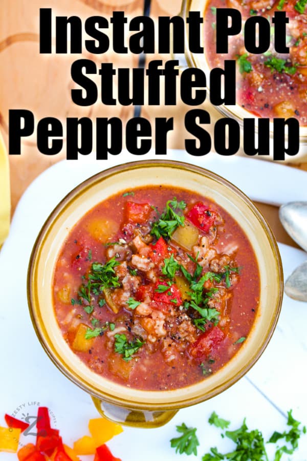 Two bowls of Instant Pot stuffed pepper soup on a cutting board.
