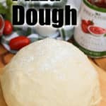 a ball of pizza dough with a can of pizza sauce on the side
