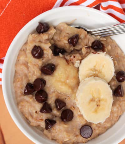 Overhead view of a bowl of peanut butter banana oatmeal with chocolate chips.