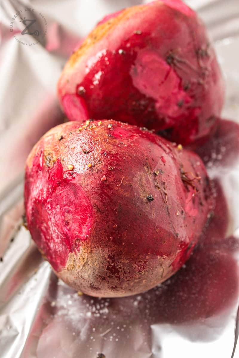 a close up of two red beets wrapped inside foil wrap