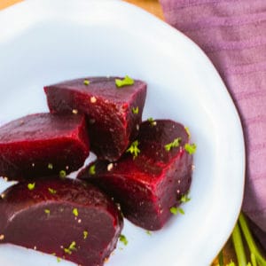 a close up of a plate of red beets cut into 5 pieces