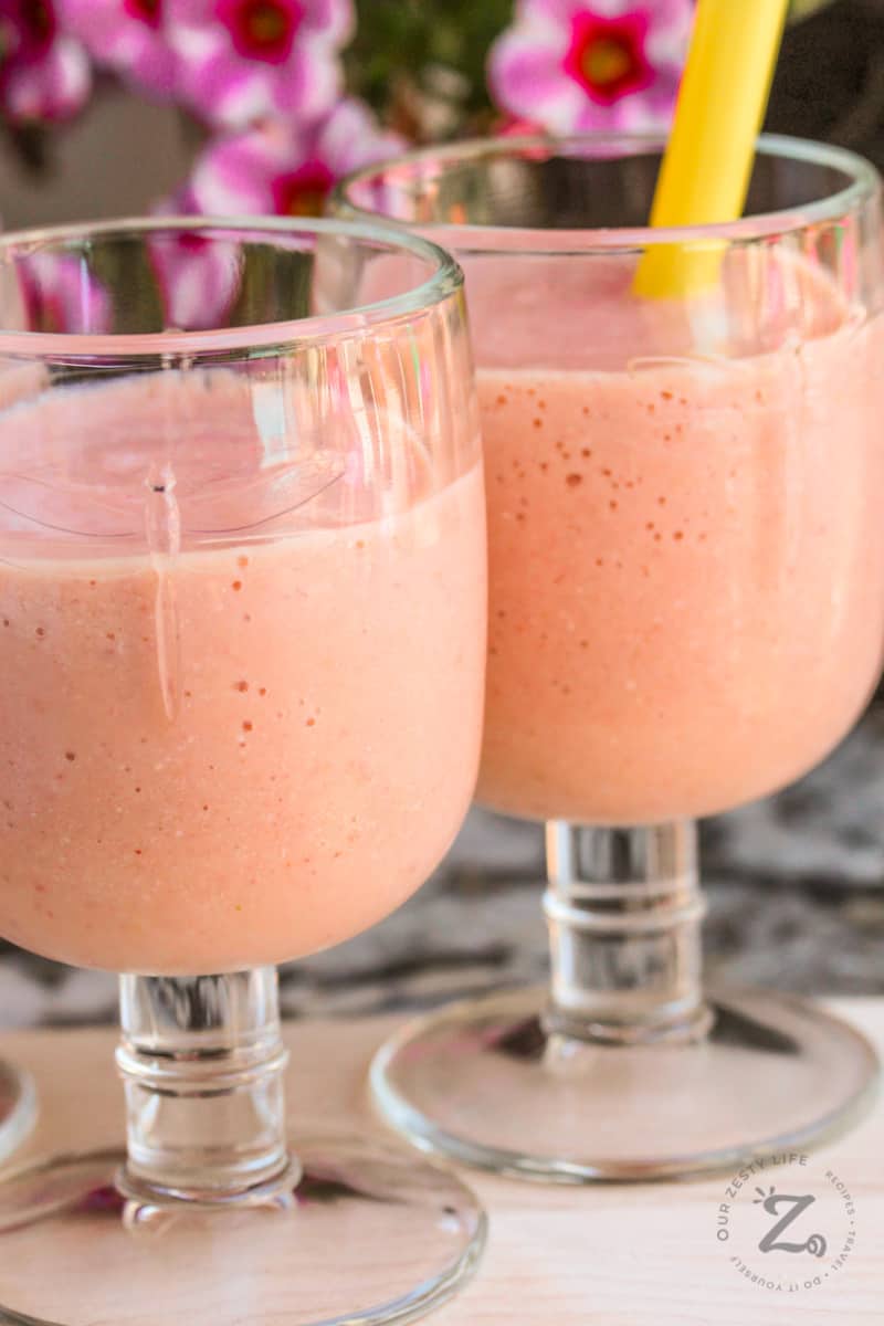 A close up of two strawberry mango smoothies on a tray