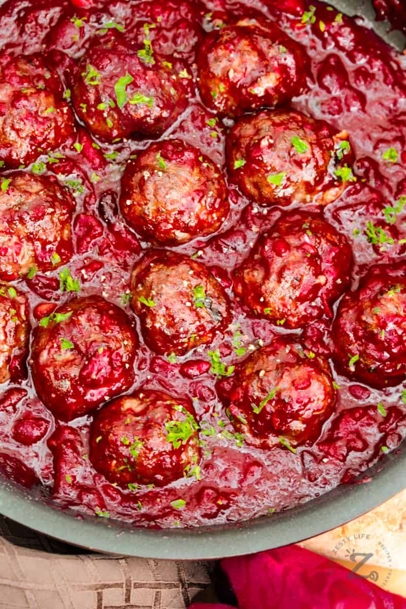 a close up of about a dozen cranberry meatballs in cranberry sauce