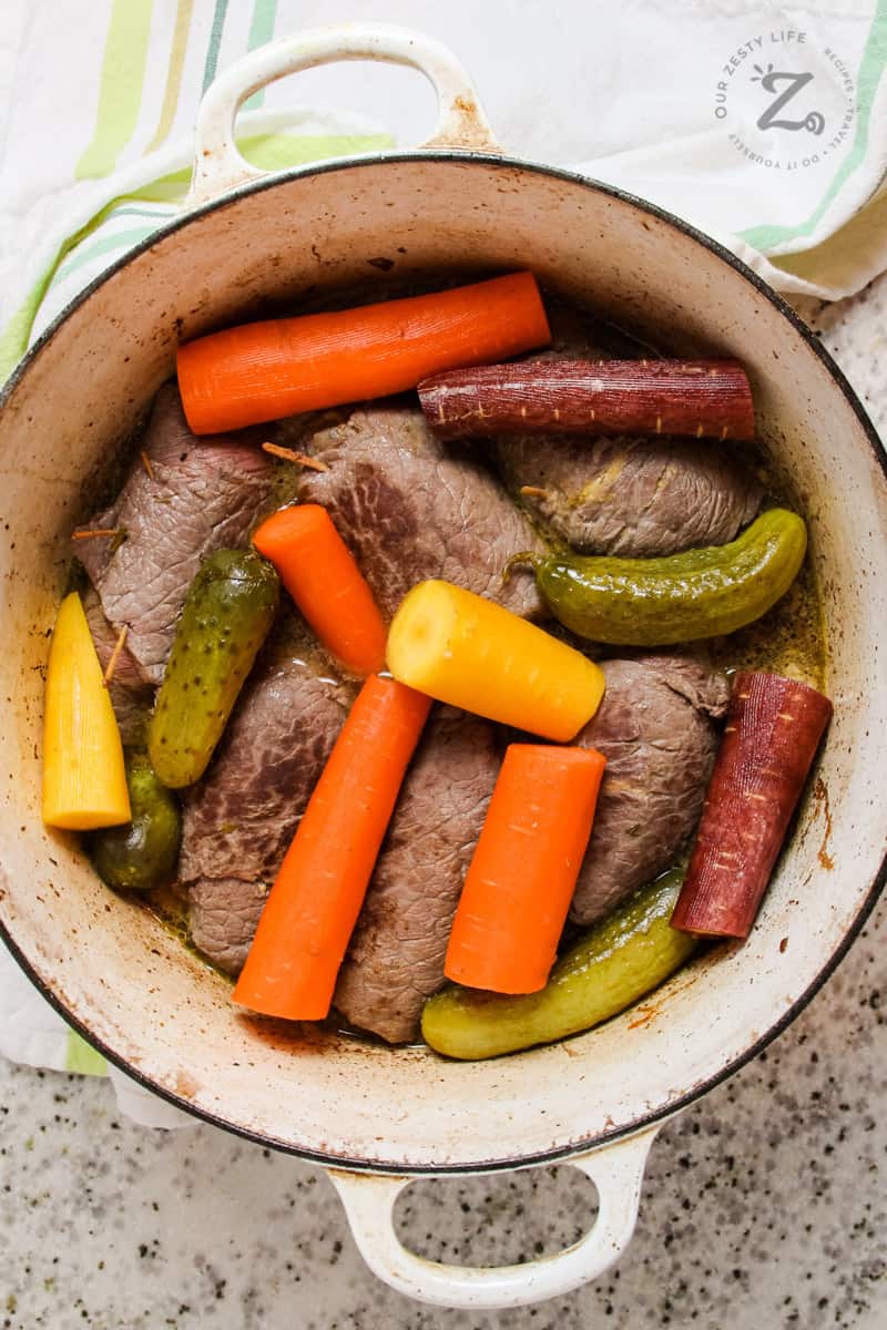Beef Rouladen in a pot with veggies and pickles 