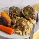 A serving of beef rouladen with macaroni and rainbow carrots