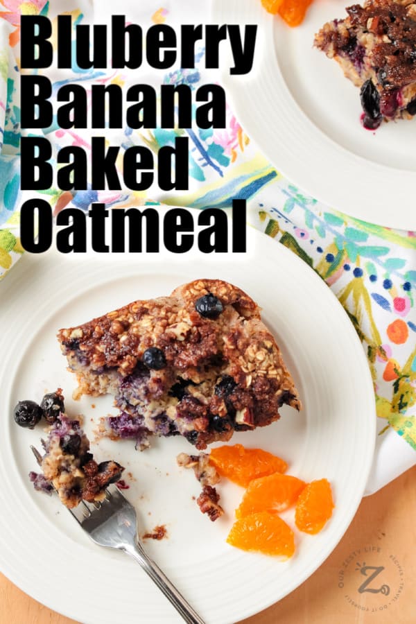 Blueberry banana baked oatmeal on a white plate with a fork and orange slices