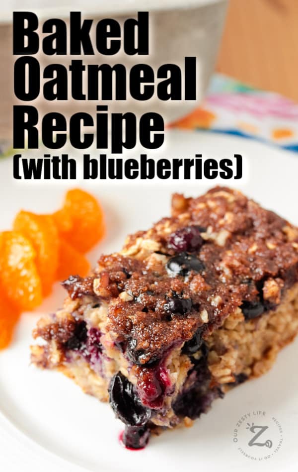 Square of blueberry banana baked oatmeal on a white plate with orange slices