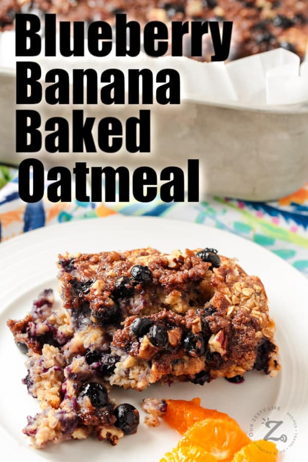 Blueberry banana baked oatmeal on a plate with slices of orange on the side