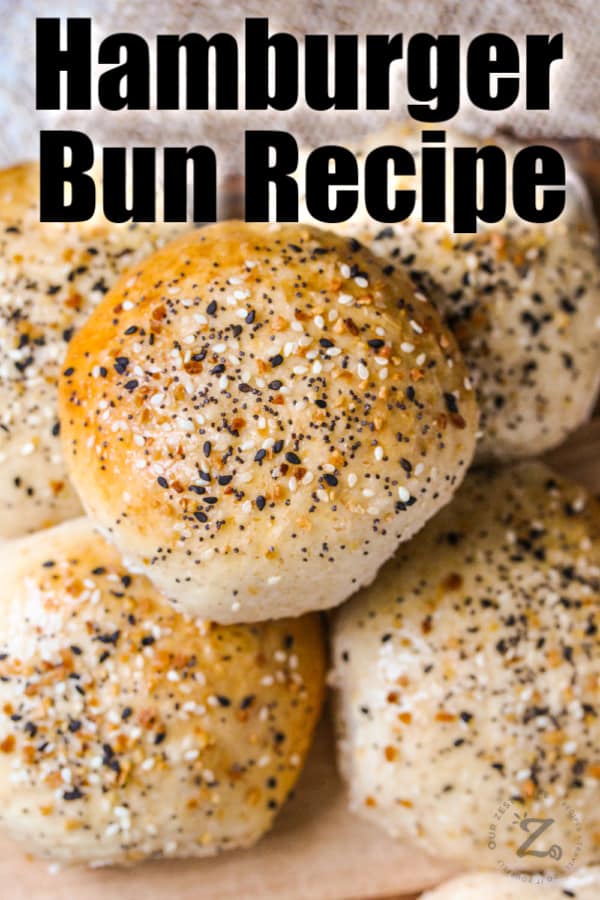 Hamburger buns in a pile with sesame seeds and a title