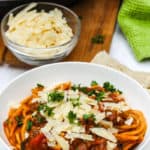 Instant Pot Bolognese in a white bowl with parmesan cheese and parsley