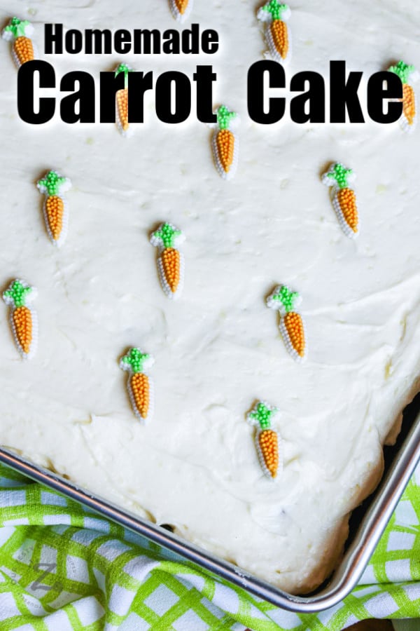 Homemade carrot cake in a pan with icing and candy carrots with text