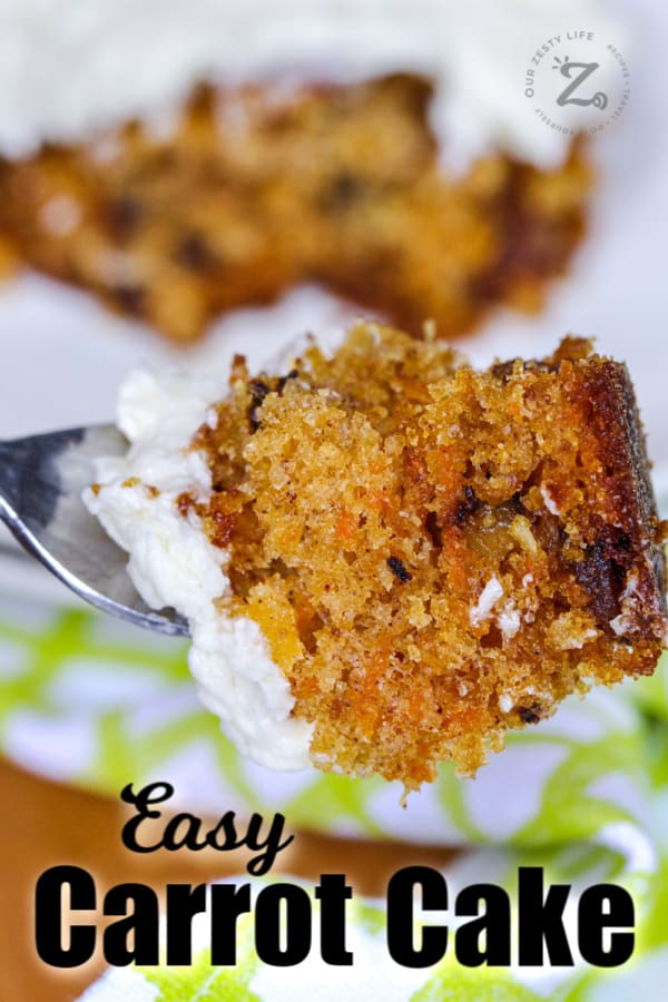 Bite of homemade carrot cake with icing on a fork with cake in the background with a title