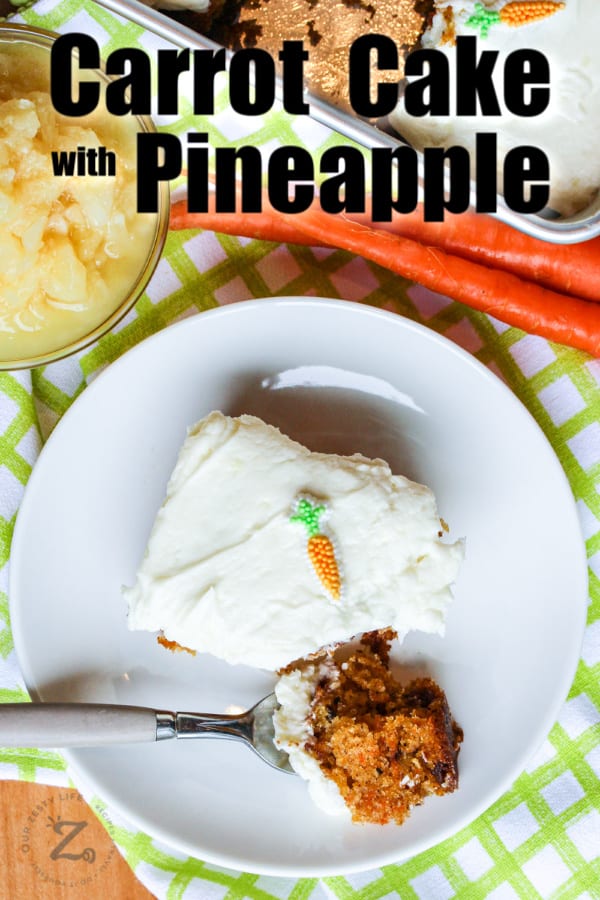 Piece of carrot cake on a plate with a bite on a fork, with carrots, pineapple and the rest of the cake on the side with writing