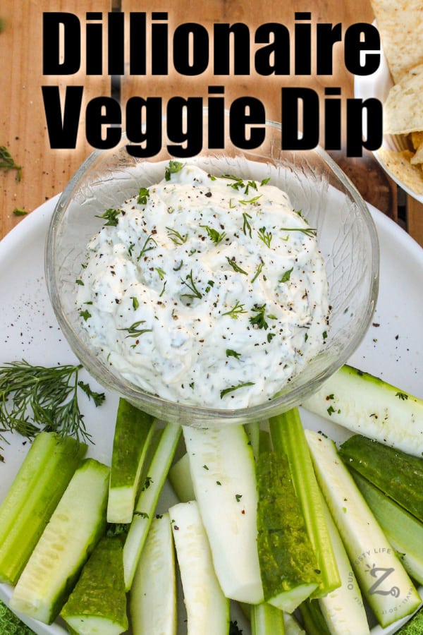 Dillionaire veggie dip in a bowl with zucchini and cucumber on a plate.