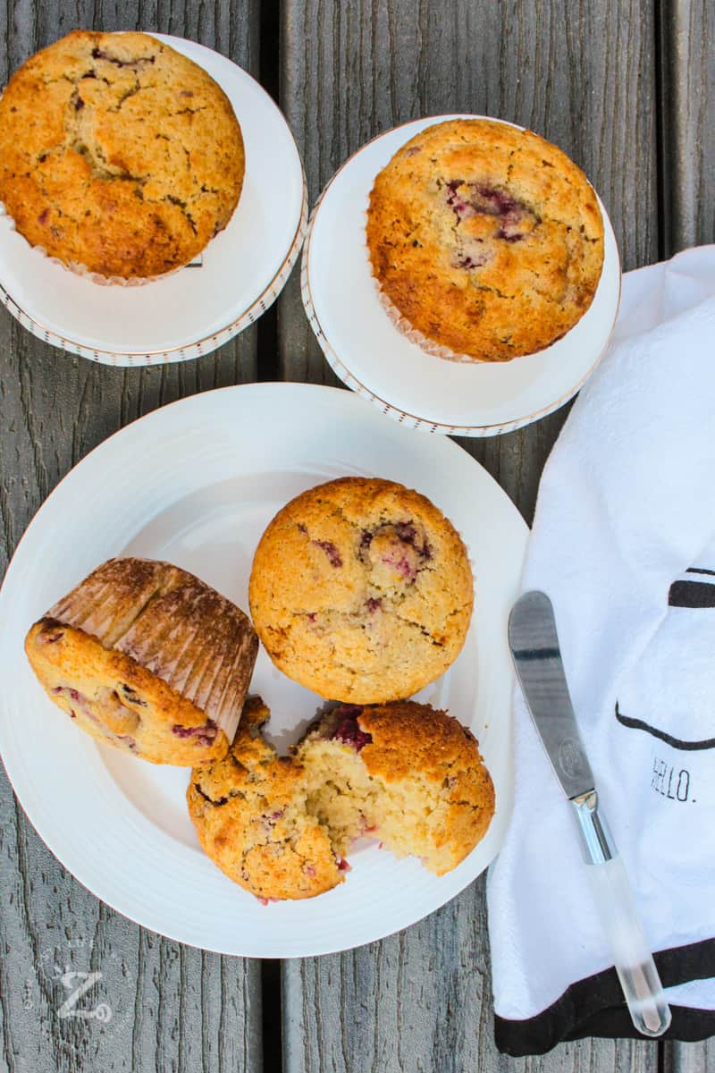 Raspberry Muffins on plates with a butter knife and a tea towel