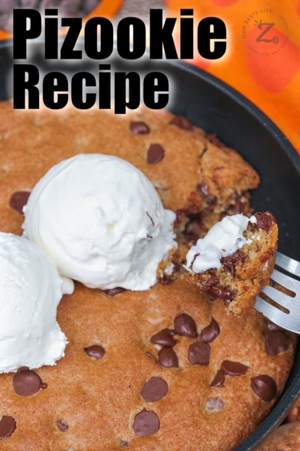 Pizookie in a pan with a fork scooping some out with writing