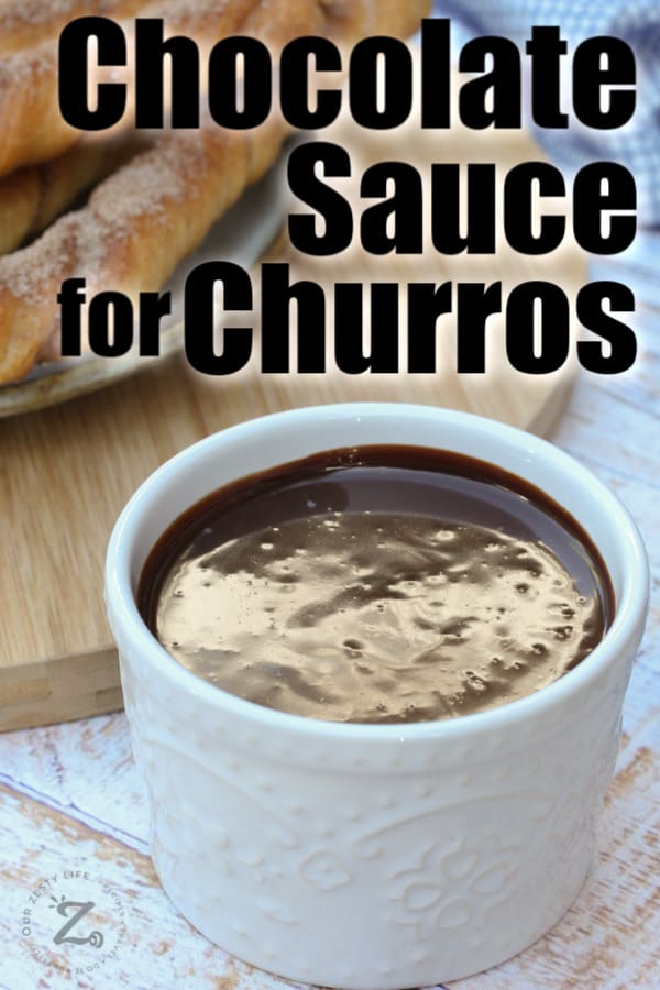 Spicy Chocolate Sauce in a white dish with churros in the background with a title