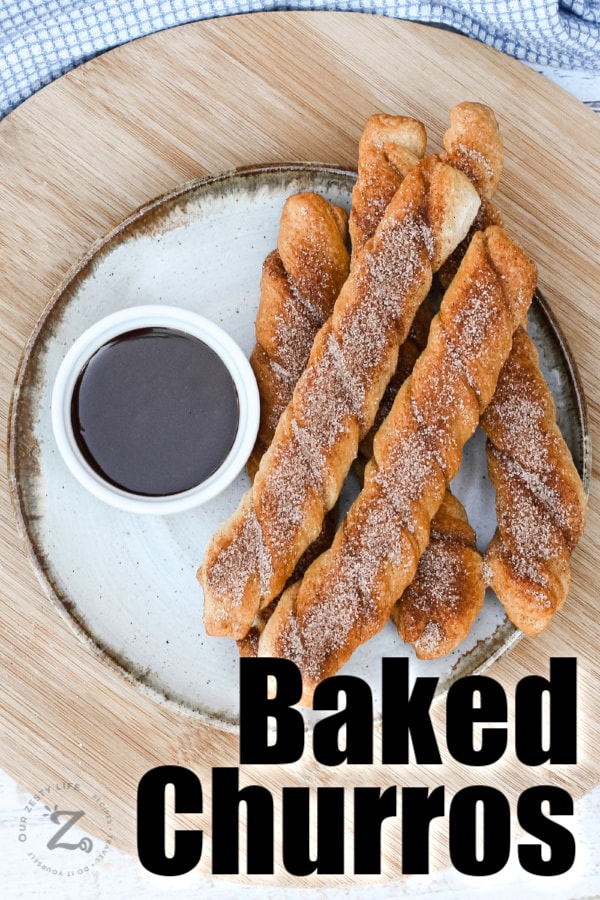 Baked Churros on a plate with chocolate sauce in a dish with writing