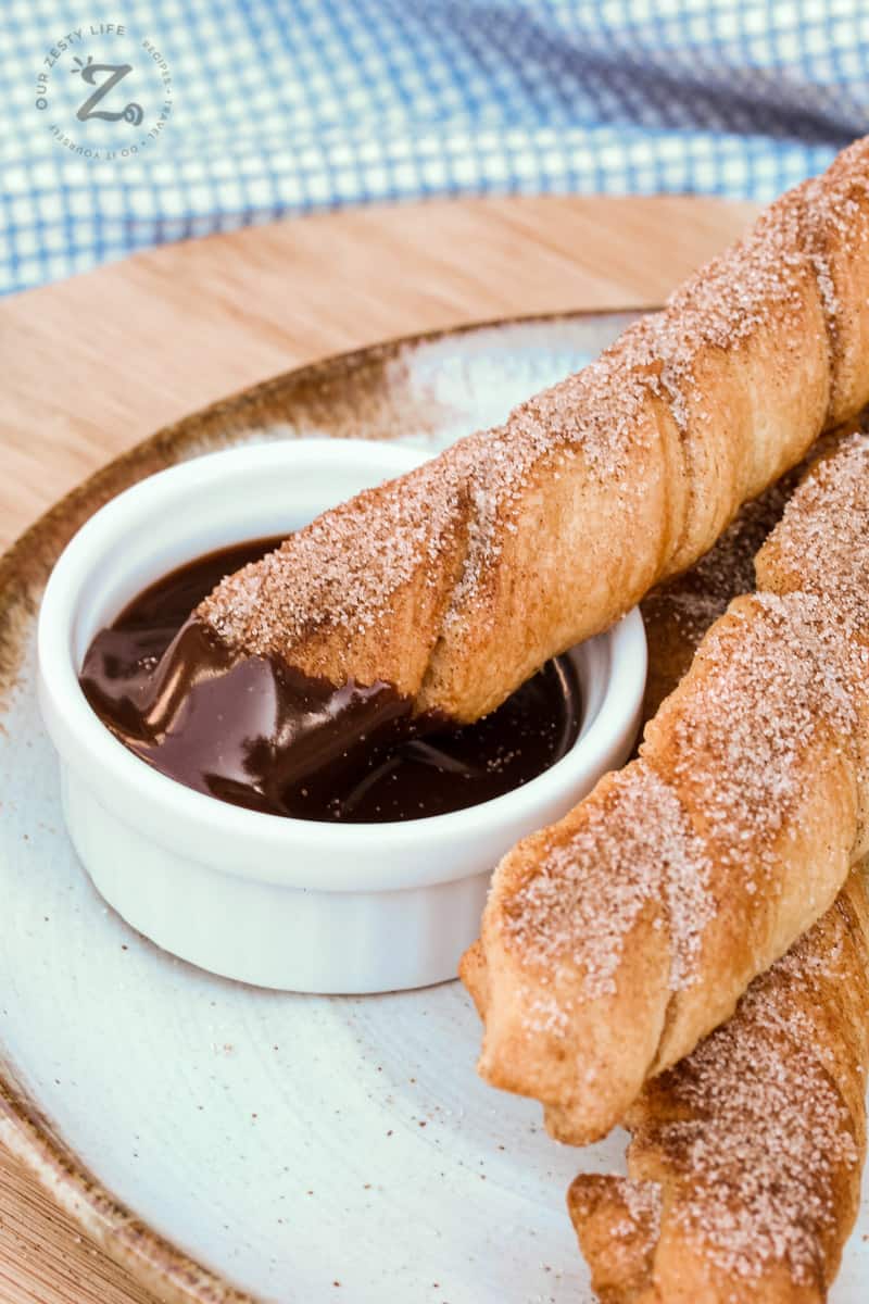 Baked Churros on a plate with chocolate sauce