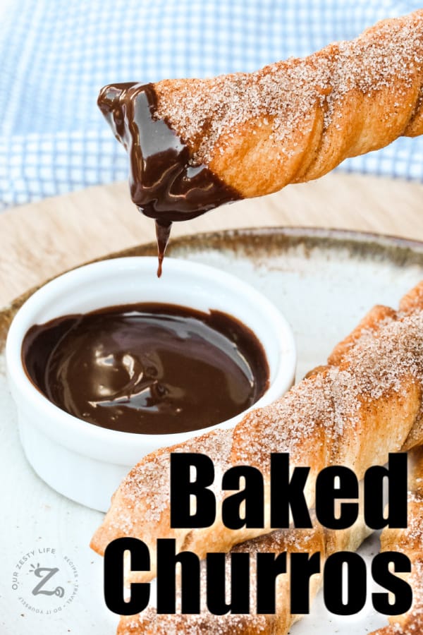 Baked Churros being dipped with chocolate sauce with writing