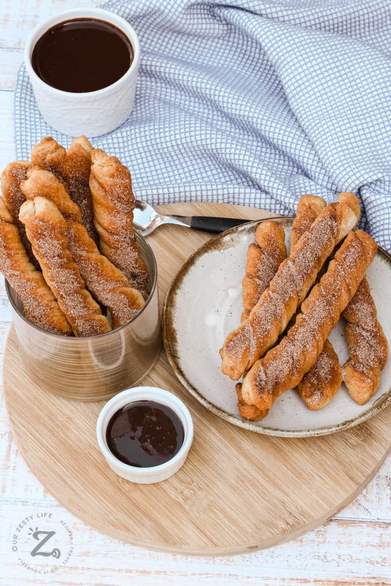 Baked Churros in a dish and on a plate with chocolate sauce
